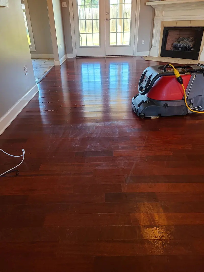 Cherry hardwood floor in a living room with a floor cleaning machine at work