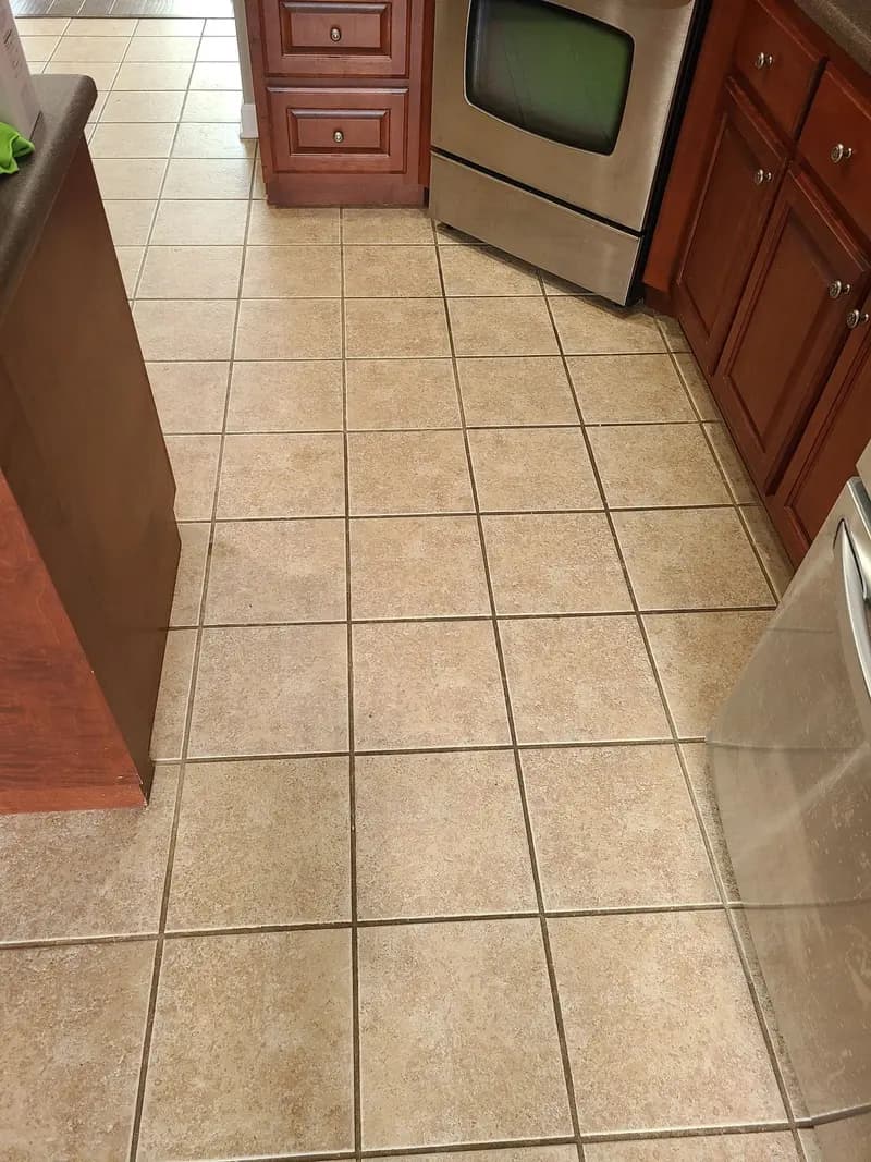Before: Kitchen tile floor with dark grout lines before cleaning