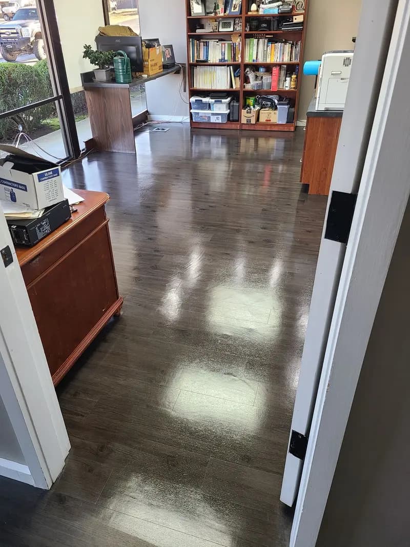 Dark luxury vinyl plank floor in an office, glossy after cleaning