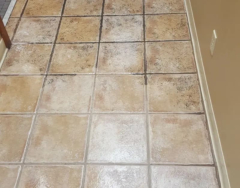 Tan tile floor partly cleaned, with dark grout lines beside freshly cleaned ones