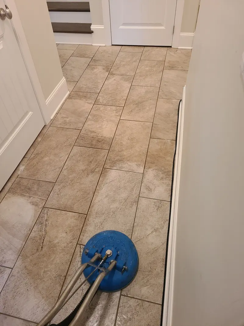 Hallway tile floor being cleaned with a spinner tool