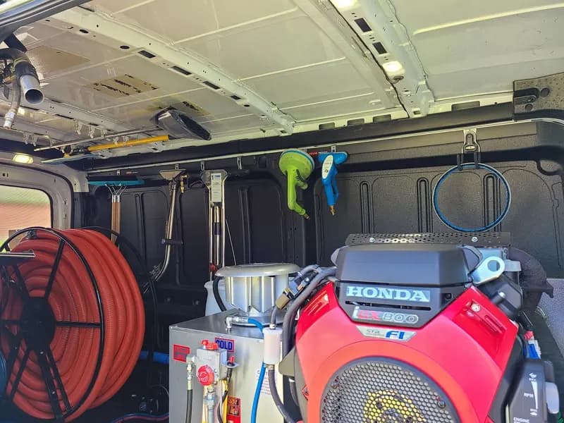 Truck-mounted cleaning machine and hose reel inside the HydroClean van