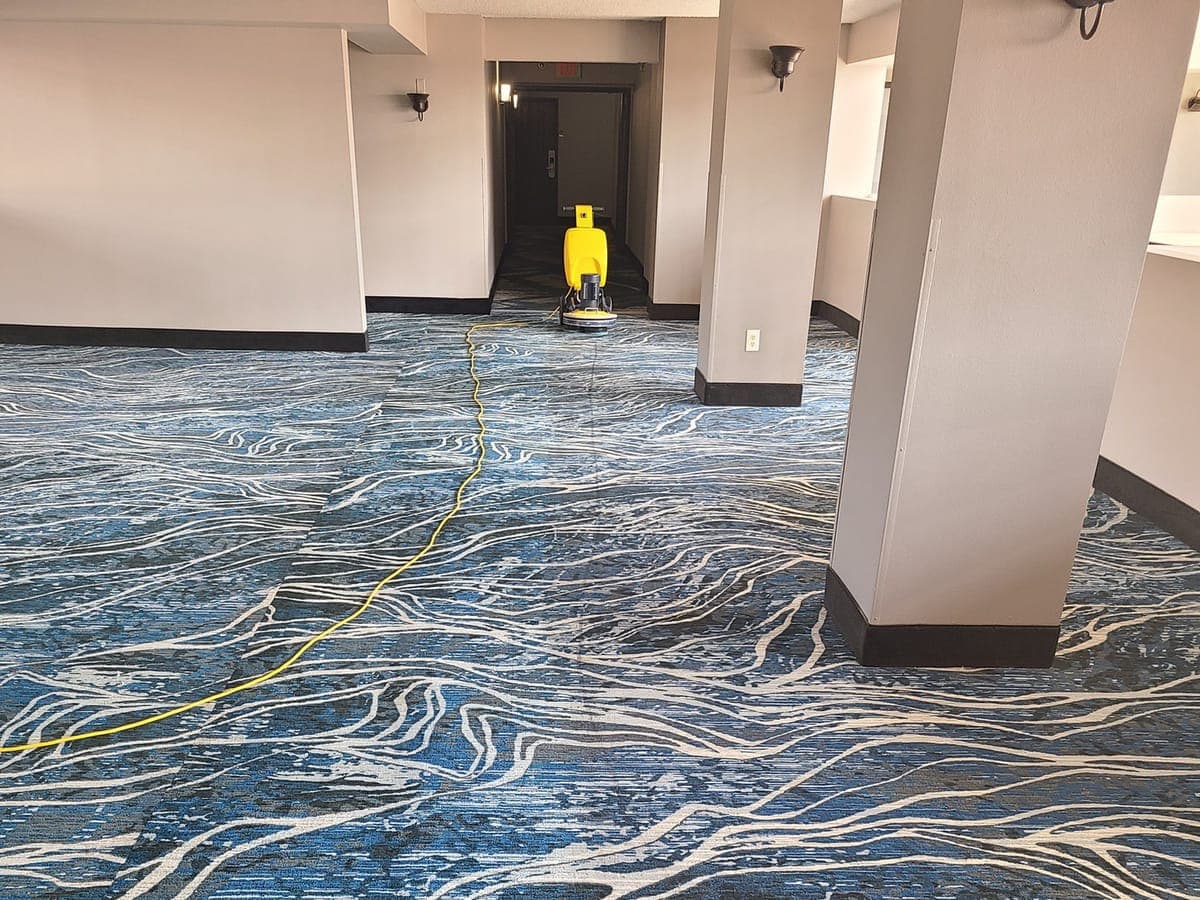 Low-moisture cleaning machine working down a patterned commercial hallway carpet