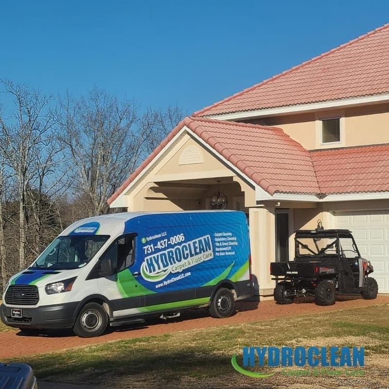 HydroClean van parked in the driveway of a two-story home