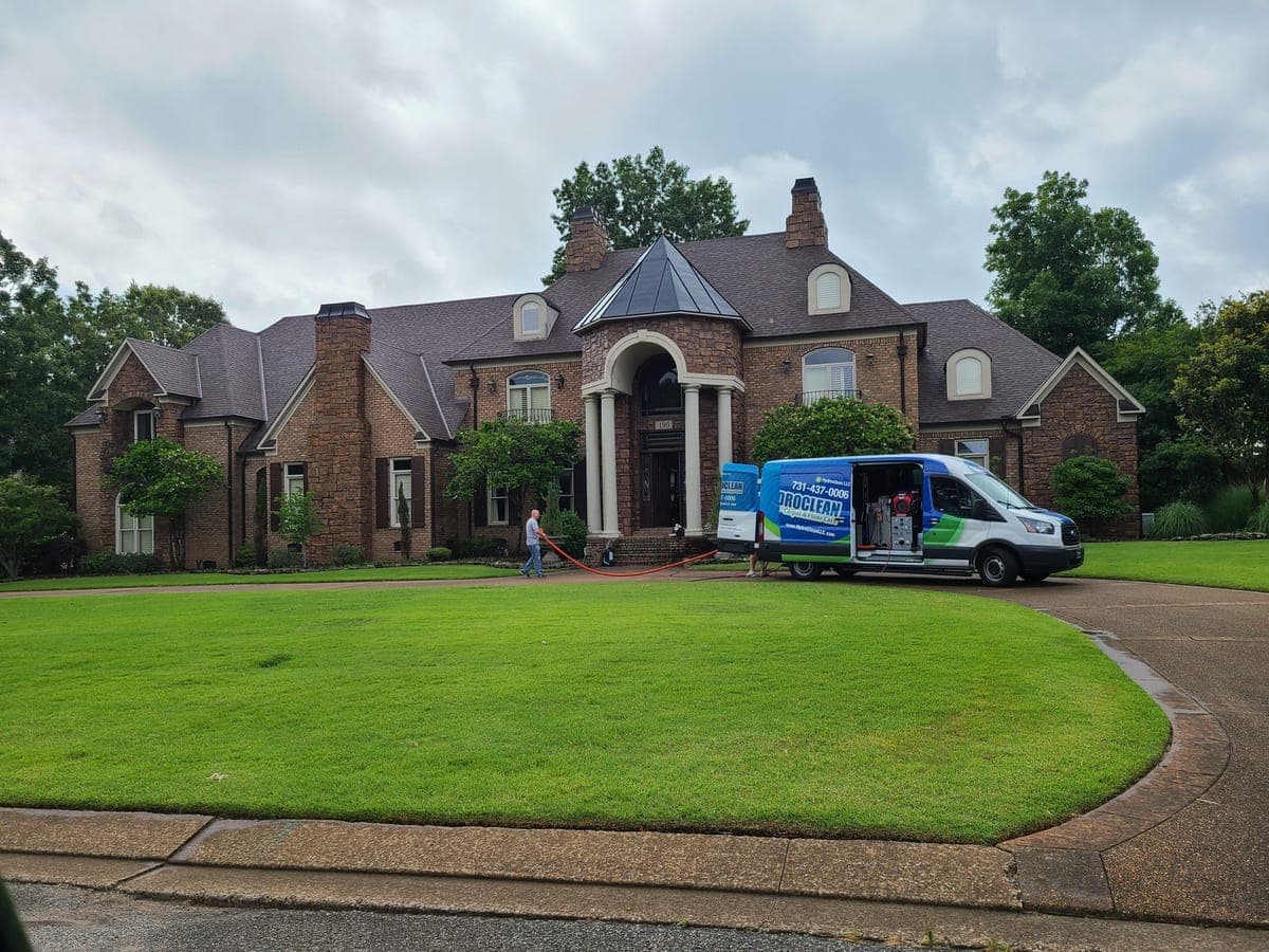HydroClean van parked in the driveway of a brick home during a job