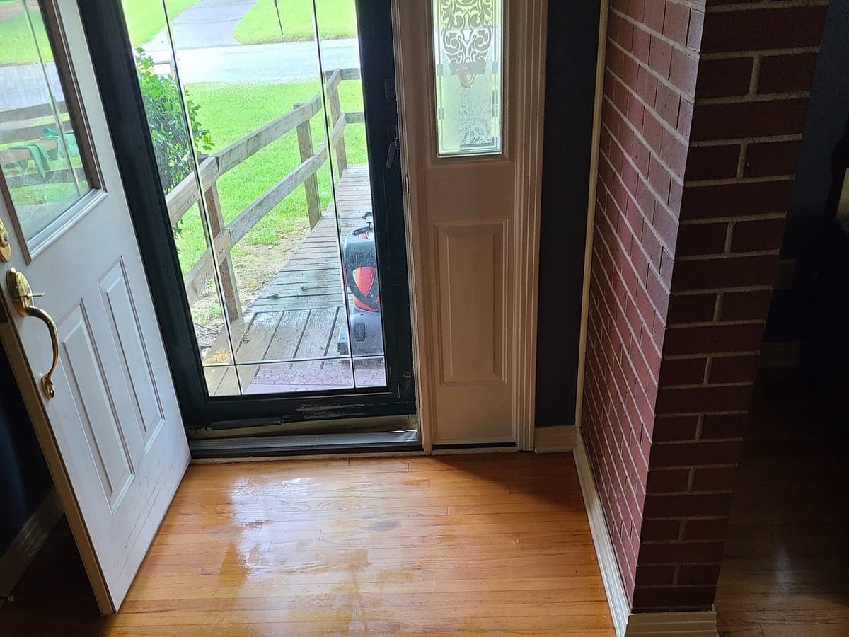 Clean oak hardwood floor in an entryway with the front door open
