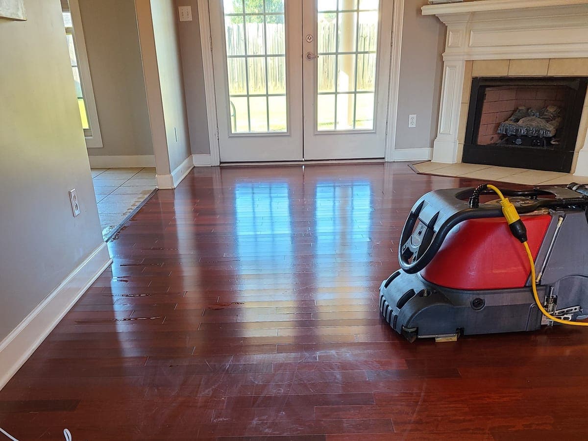 Cherry hardwood floor in a living room with a floor cleaning machine at work