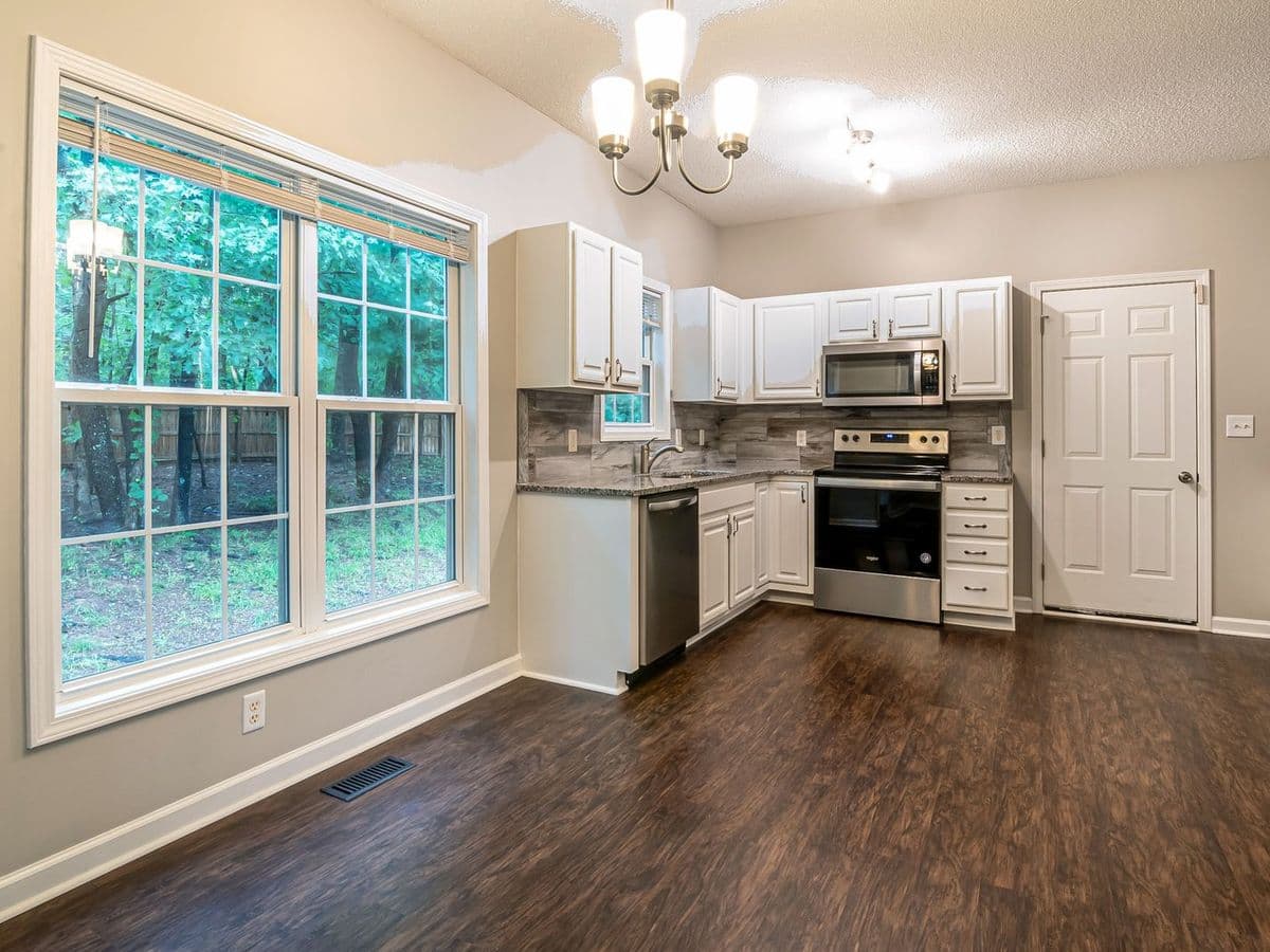 Dark wood-look plank floor in a kitchen with white cabinets