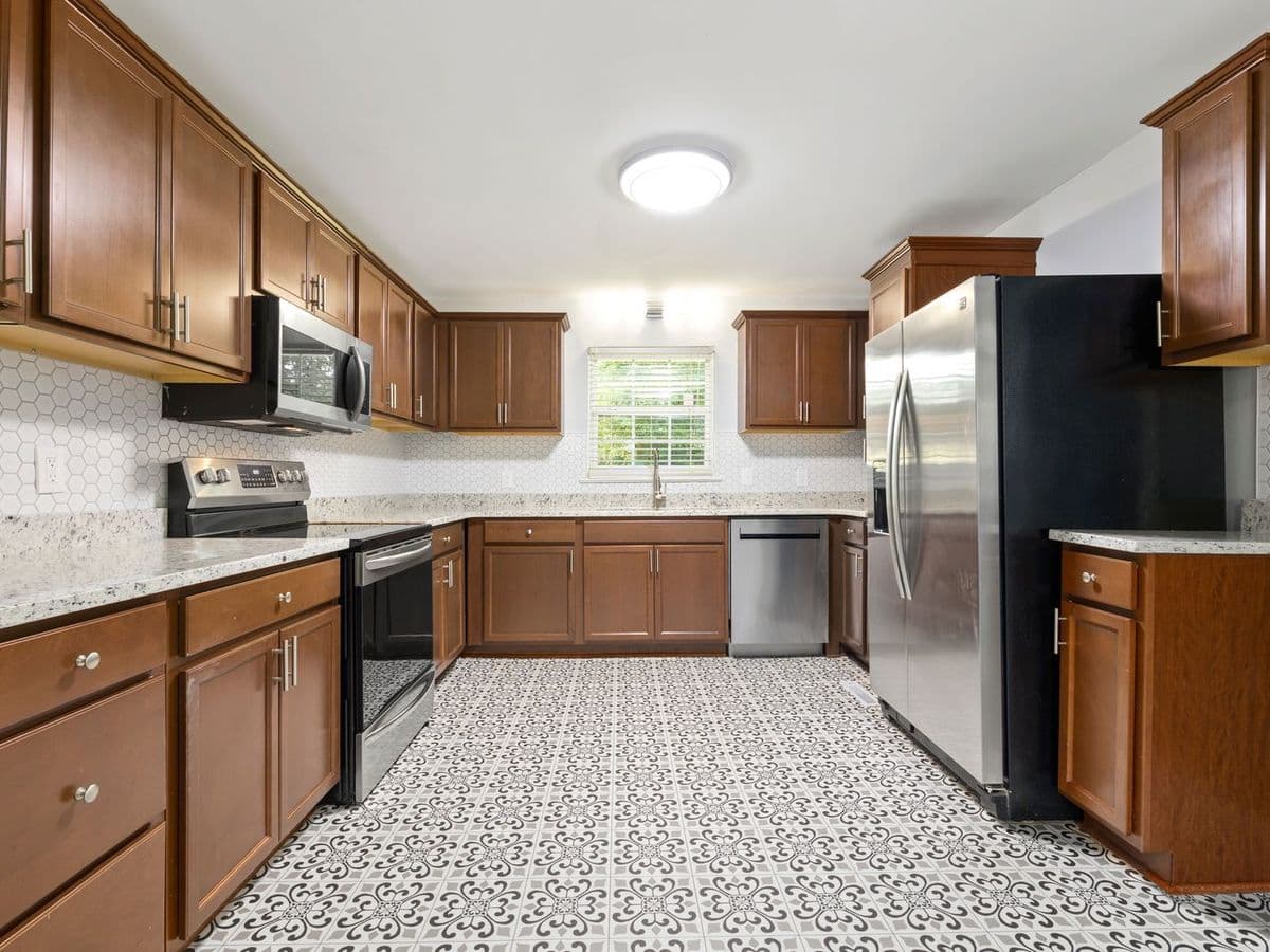 Patterned tile floor in a kitchen with wood cabinets