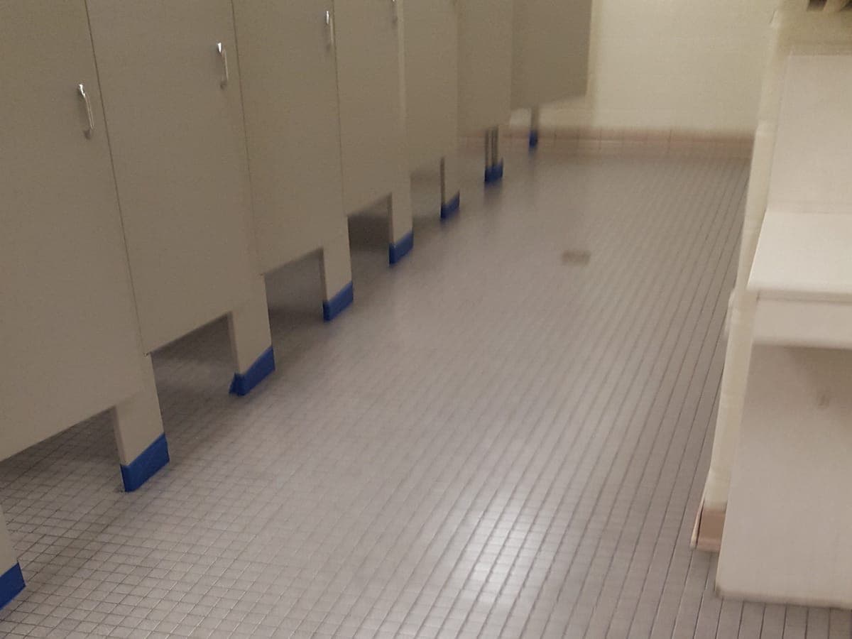 Commercial restroom with small square floor tile after cleaning