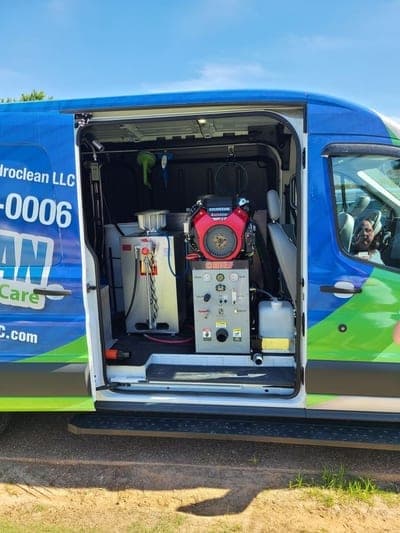 Truck-mounted cleaning unit inside the open side door of the HydroClean van