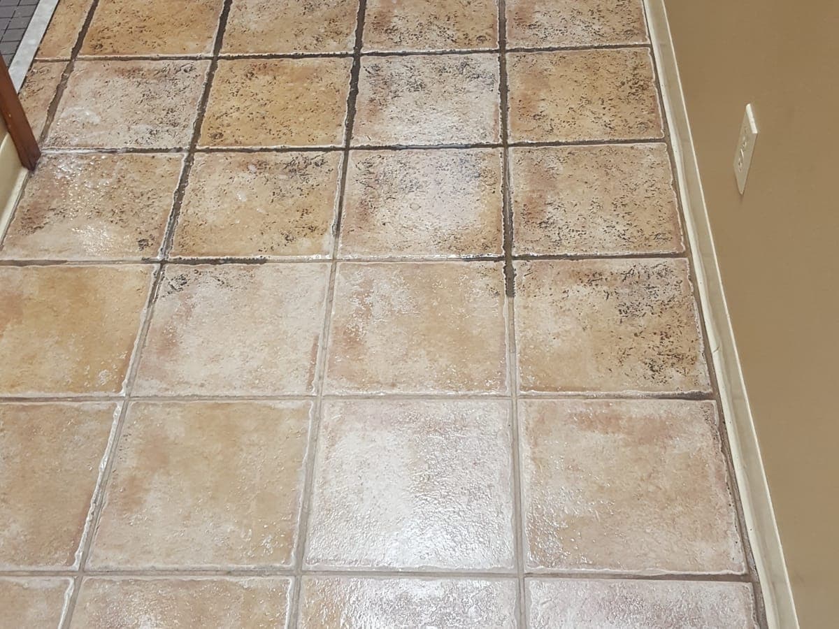 Tan tile floor partly cleaned, with dark grout lines beside freshly cleaned ones