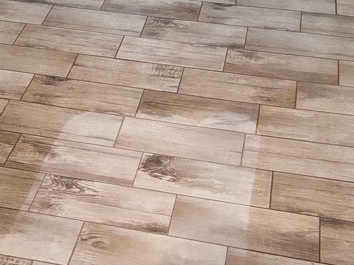 Wood-look plank tile floor with a lighter cleaned path across it