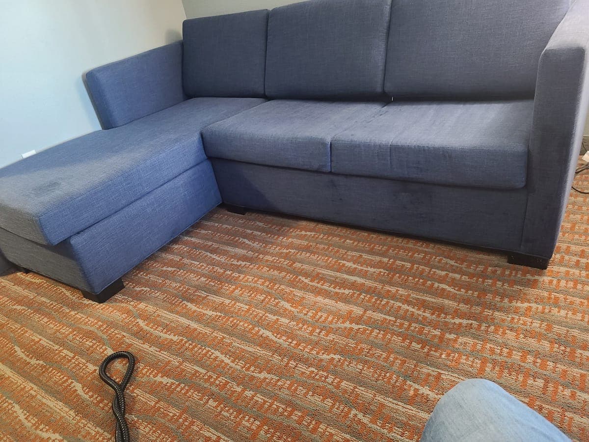 Blue sectional sofa and patterned carpet after cleaning