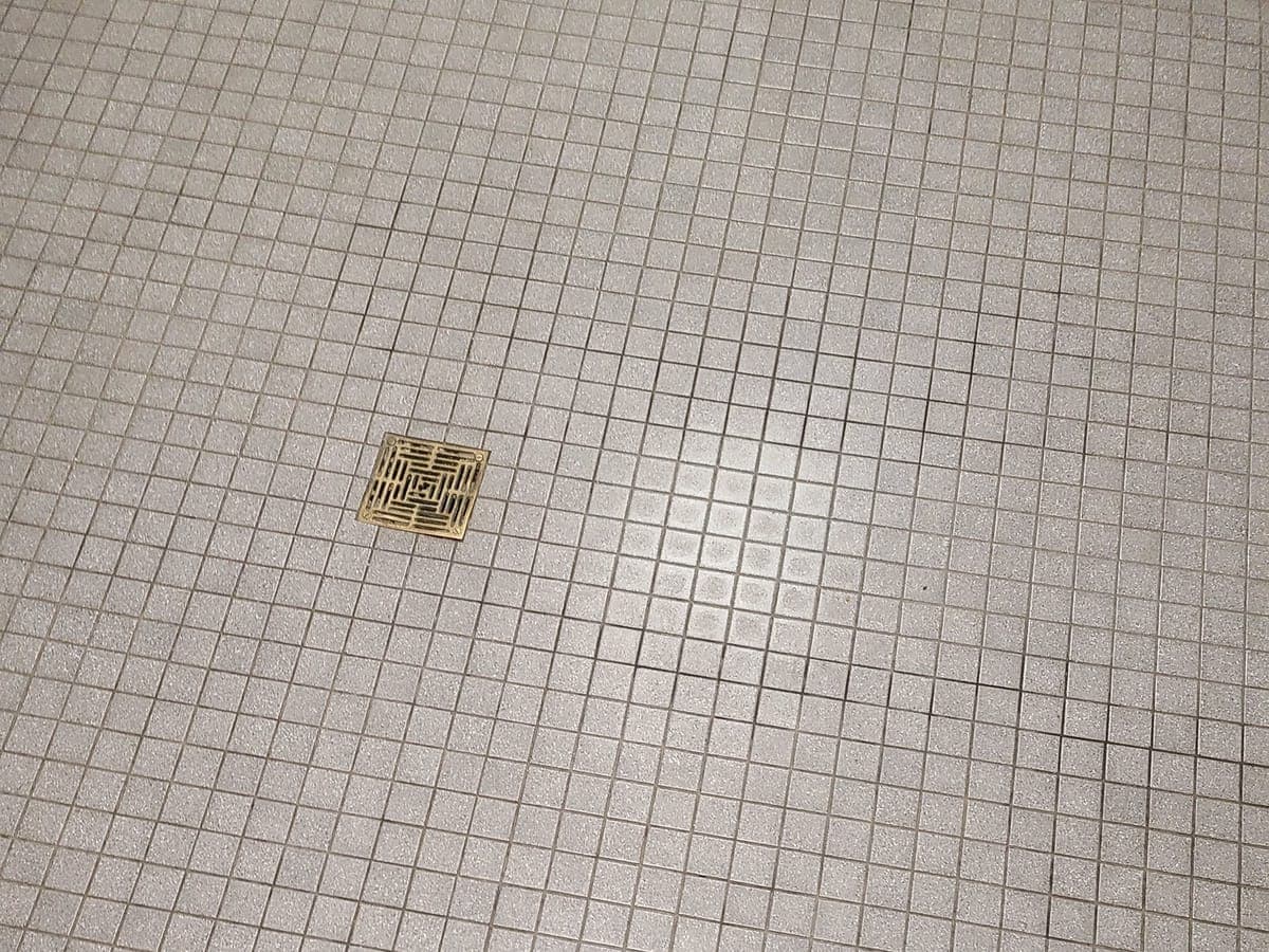 Small square tile floor around a floor drain after cleaning