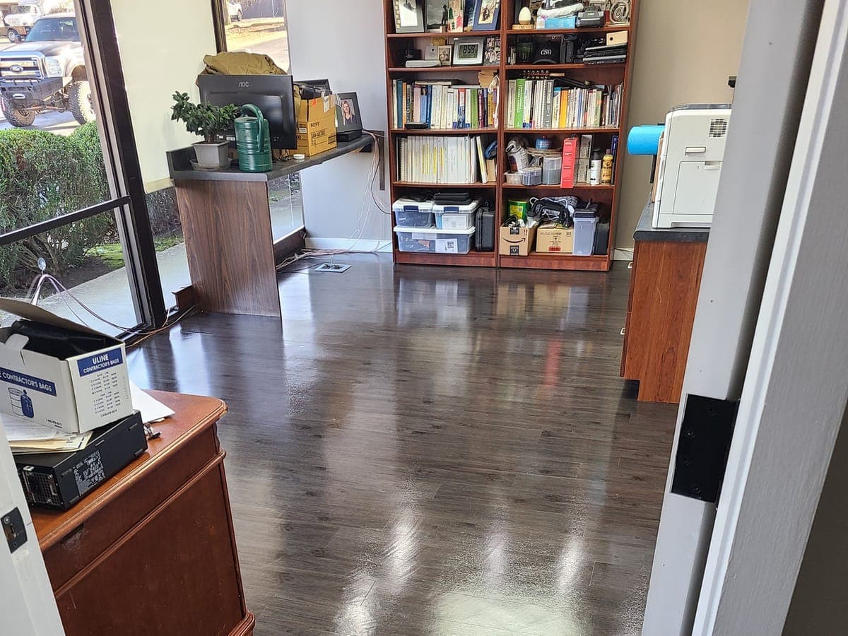 Dark luxury vinyl plank floor in an office, glossy after cleaning